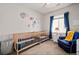 Cozy Bedroom featuring dual cribs, a comfortable chair, and playful space themed decor at 15246 W 94Th Ave, Arvada, CO 80007