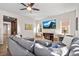 Comfortable living room featuring a large gray sectional sofa, ceiling fan, and decorative media center at 15246 W 94Th Ave, Arvada, CO 80007