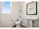 A simple powder room design that includes a toilet and a pedestal sink at 15246 W 94Th Ave, Arvada, CO 80007