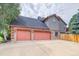 Two-car garage with double doors and a large driveway at 3351 Oak St, Wheat Ridge, CO 80033