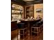 The bar boasts dark wood finishes, marbled backdrop, seating, and ample display shelving at 4603 S Denice Dr, Cherry Hills Village, CO 80111
