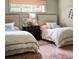 Bright bedroom featuring two twin beds with patterned carpet and neutral walls at 4603 S Denice Dr, Cherry Hills Village, CO 80111
