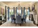 Formal dining room featuring a large table with seating for ten, fireplace, and backyard views at 4603 S Denice Dr, Cherry Hills Village, CO 80111