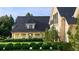 Elegant home exterior showcases stone accents, black roofing and verdant, well-manicured greenery at 4603 S Denice Dr, Cherry Hills Village, CO 80111