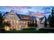 Stunning estate with stone facade, multiple balconies and patios, illuminated by evening lights at 4603 S Denice Dr, Cherry Hills Village, CO 80111