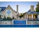 Luxury home exterior featuring a swimming pool, stone facade, arched window, and lush landscaping at 4603 S Denice Dr, Cherry Hills Village, CO 80111