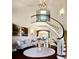 Elegant foyer features a curved staircase, dark wood floors, and sophisticated decor at 4603 S Denice Dr, Cherry Hills Village, CO 80111