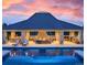Outdoor pool house with fireplace and lounge area overlooking swimming pool with beautiful sunset at 4603 S Denice Dr, Cherry Hills Village, CO 80111