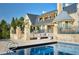 Luxury home showcasing swimming pool, patio, and stone exterior with manicured gardens at 4603 S Denice Dr, Cherry Hills Village, CO 80111