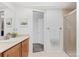 Well-lit bathroom featuring a vanity, a mirror with framed artwork, and glass-enclosed shower at 12979 W Ohio Ave, Lakewood, CO 80228