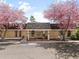 Charming community clubhouse entrance framed by blossoming pink trees, offering a welcoming gathering space at 12979 W Ohio Ave, Lakewood, CO 80228