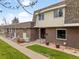 A view of the front exterior reveals a brick townhome and a well-manicured lawn at 12979 W Ohio Ave, Lakewood, CO 80228