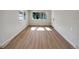 Bright living room with wood floors, two windows for natural light, and fresh white trim at 6650 Depew Ct, Arvada, CO 80003