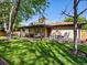 Spacious backyard with a well-maintained lawn, mature trees, and a relaxing seating area at 6943 Oak Way, Arvada, CO 80004