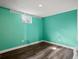 Bright basement space with painted teal walls, wood-look floors and recessed lighting at 6943 Oak Way, Arvada, CO 80004