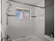 Bright white bathroom showcasing white subway tile, a tub, and frosted window for natural light at 6943 Oak Way, Arvada, CO 80004