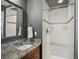 Bathroom with granite countertop, a white tiled shower with a bench, and modern fixtures at 6943 Oak Way, Arvada, CO 80004