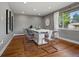 Dining room with hardwood floors, a modern table with ghost chairs, and a bright window at 6943 Oak Way, Arvada, CO 80004