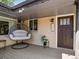 Inviting front porch featuring a hanging chair, stylish door, and address plaque at 6943 Oak Way, Arvada, CO 80004
