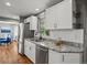 Kitchen with granite countertops, stainless steel appliances, white cabinets, and a window at 6943 Oak Way, Arvada, CO 80004