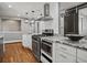 Kitchen with stainless steel appliances, granite countertops, white cabinets, and hardwood floors at 6943 Oak Way, Arvada, CO 80004