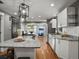 Open kitchen featuring granite countertops, stainless steel appliances, white cabinets, and hardwood floors at 6943 Oak Way, Arvada, CO 80004