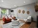 Cozy living room featuring hardwood floors, an orange sofa, accent chair, and decorative wall art at 6943 Oak Way, Arvada, CO 80004