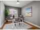 Bright office space features hardwood floors, a modern desk, and a serene beach painting at 6943 Oak Way, Arvada, CO 80004