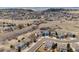 Aerial view shows a large residential area with houses spread out among green spaces and rolling hills at 1022 Orion Way, Castle Rock, CO 80108