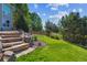 Landscaped backyard with stone steps and lush greenery, offering a tranquil outdoor space at 1022 Orion Way, Castle Rock, CO 80108