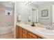 Bathroom with double sinks, oak cabinets, and a large mirror at 1022 Orion Way, Castle Rock, CO 80108