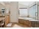 Bathroom with double sinks, vanity, shower and soaking tub under a glass block window at 1022 Orion Way, Castle Rock, CO 80108