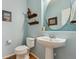Charming powder room with pedestal sink, wood look floors and stylish decor at 1022 Orion Way, Castle Rock, CO 80108