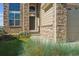 A welcoming front entrance featuring a stone facade, an ADT security sign, and lush landscaping at 1022 Orion Way, Castle Rock, CO 80108