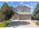 Two-story home boasts a two-car garage, mature landscaping, and a well-maintained lawn under a bright, blue sky at 1022 Orion Way, Castle Rock, CO 80108