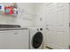 Functional laundry room with modern washer and dryer, and convenient shelving at 1022 Orion Way, Castle Rock, CO 80108