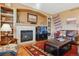 Cozy living room with a fireplace, built-in shelves, and comfortable leather furniture at 1022 Orion Way, Castle Rock, CO 80108