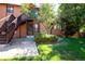 The exterior of the two-story home features wooden siding, a stone chimney, and a staircase leading to a second-story entrance at 9402 W 89Th Cir, Broomfield, CO 80021