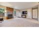 Cozy living room with a stone fireplace, neutral-toned walls and carpet, and a mounted television for entertainment at 9402 W 89Th Cir, Broomfield, CO 80021