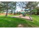 Community playground featuring a green lawn, slide, and wood fencing at 9402 W 89Th Cir, Broomfield, CO 80021