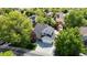Aerial view of a well-situated home featuring a spacious driveway and a charming red barn-style shed, nestled in a lush neighborhood at 10635 Dexter Dr, Thornton, CO 80233