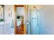 Charming bathroom featuring a walk-in shower and vanity, leading into another room with hardwood floors at 10635 Dexter Dr, Thornton, CO 80233
