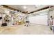 Spacious garage featuring storage shelves and work table, ideal for DIY projects and secure parking at 10635 Dexter Dr, Thornton, CO 80233