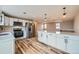 Spacious kitchen featuring stainless steel appliances, white cabinets, quartz countertops, and an adjacent living area at 1152 S Salida Way, Aurora, CO 80017