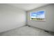 This bedroom features neutral carpet and a large window showing the neighborhood at 260 E 4Th St, Berthoud, CO 80513