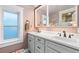 Bright bathroom features a double vanity, framed mirrors, and a large window at 890 S Vine St, Denver, CO 80209