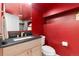 Stylish half bath with bold red walls, updated vanity, and modern fixtures at 890 S Vine St, Denver, CO 80209