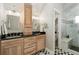 Bright bathroom featuring double vanity, wooden cabinets, and marble-tiled walk-in shower at 890 S Vine St, Denver, CO 80209