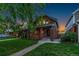 Charming brick home with a well-maintained lawn, mature trees, and inviting curb appeal at dusk at 890 S Vine St, Denver, CO 80209