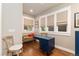 Bright office space features a blue desk, hardwood floors, and ample natural light from the three windows at 890 S Vine St, Denver, CO 80209